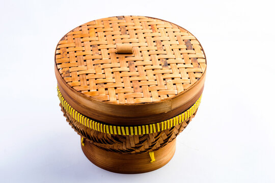 A ceting bambu is a traditional woven bamboo container for storing rice, isolated against a white background.