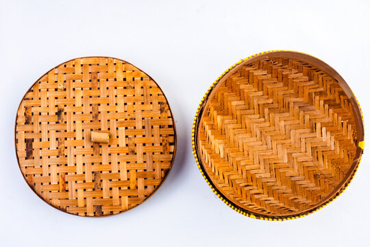 A ceting bambu is a traditional woven bamboo container for storing rice, isolated against a white background.