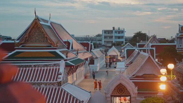 BANGKOK, THAILAND - 23 September 2026: High angle view of buddhist monks in orange robes walking through a traditional temple in bangkok