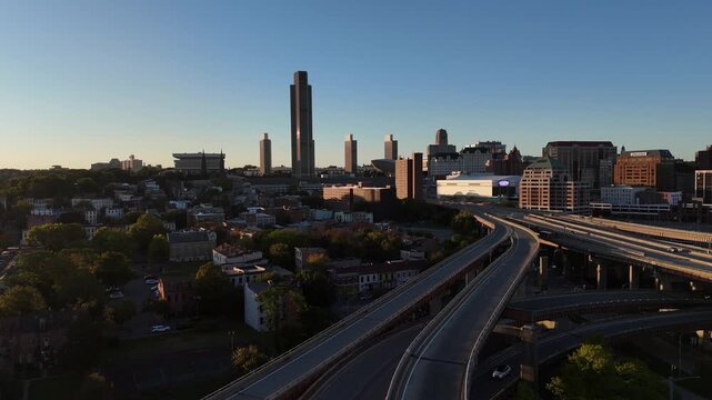 Panoramic aerial view of the Albany New York skyline and highway interchange glowing in the warm light of a late afternoon sunset 4k aerial drone video