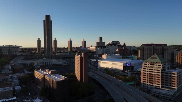 Close-up aerial view of downtown Albany New York skyscrapers and architecture bathed in the warm light of a late afternoon sunset 4k aerial drone video