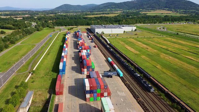 Nosovice, Czechia - 28 August 2026: Aerial view of a container terminal and railway yard with colorful shipping containers and freight trains in the Moravian-Silesian Region.