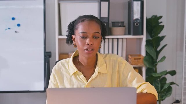 Confident African American businesswoman speaking and explaining ideas directly to camera during a video call meeting in a bright office