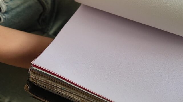 Close up of a female hand browsing fabric samples to choose material for roller blinds for home Interior design and window treatment concept focused on selecting colors textures and fabrics for decor