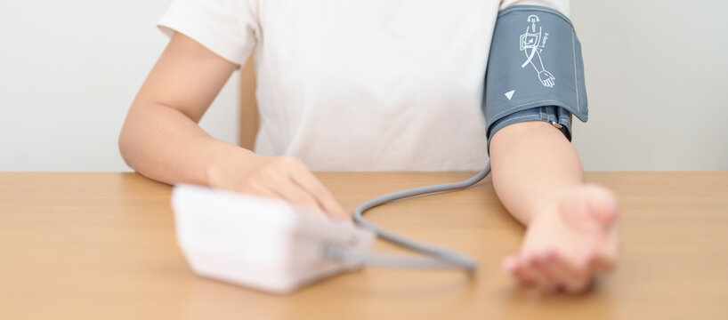 woman checking Blood pressure by Blood pressure monitor with Cuff. Systolic, SYS, Diastolic, DIA, Pulse, Hypertension, Hypotension, Heart rate, Cardiovascular Disease and May World hypertension day