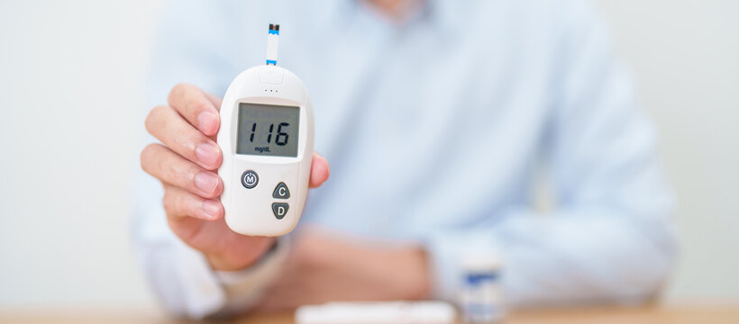 Hand checking Diabetes or Blood glucose self testing by digital blood glucose meter with lancet pen. high blood sugar level, World Diabetes Day, Glycemia, Hypoglycemia, Hyperglycemia and insulin