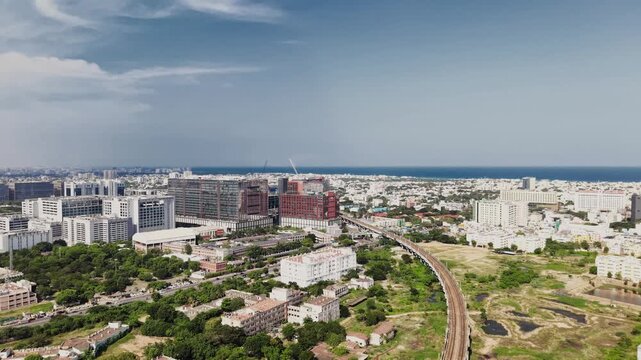 Chennai, India - 12 September 2026: Aerial view of DLF Downtown featuring modern office buildings, a railway track, and the surrounding urban landscape under a clear blue sky.