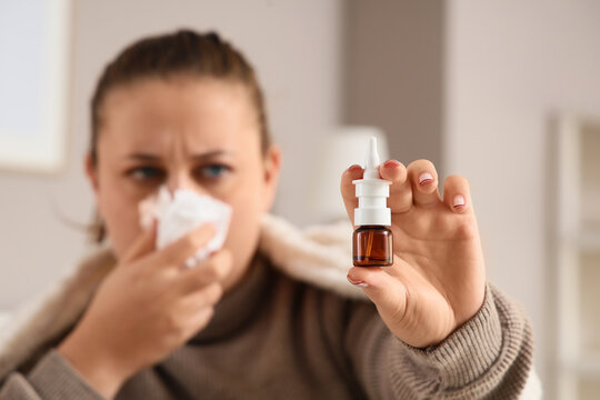 Allergy relief and cold treatment, woman holding nasal spray bottle with tissue for seasonal flu symptoms and sinus congestion in home environment