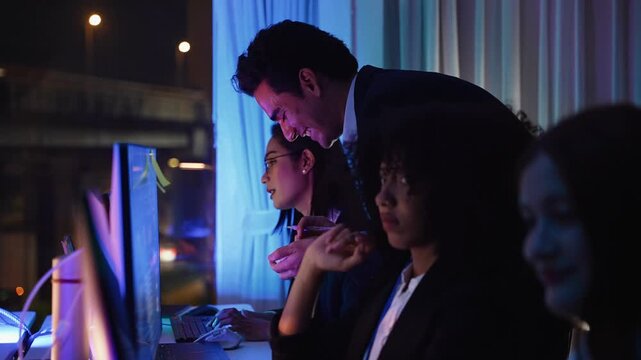 A business team works late at night in an office, collaborating on software projects using computers and reviewing documents together with dedication and focus.