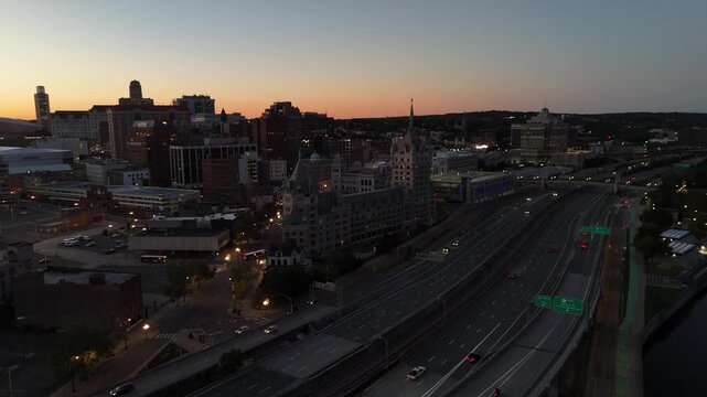 Interstate 787 running alongside downtown Albany New York and the Hudson River at twilight 4k aerial drone video