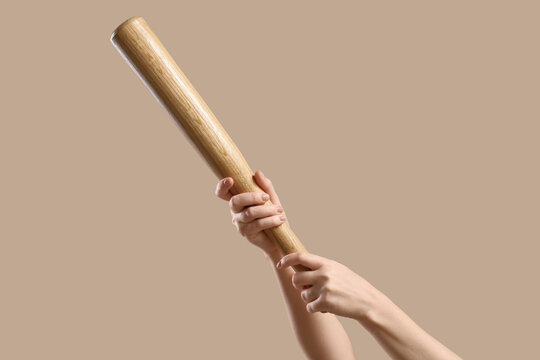 Aggression and violence concept, person holding a wooden baseball bat in a threatening posture for self defense or sports competition preparation
