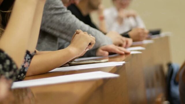 Students Attending Conference Presentation And Taking Notes In Auditorium