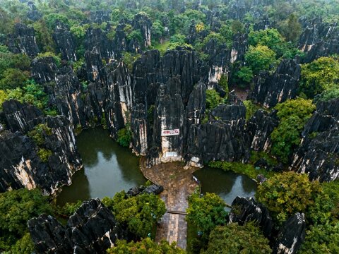 Aerial view of a limestone karst landscape with a central temple surrounded by water and dense greenery