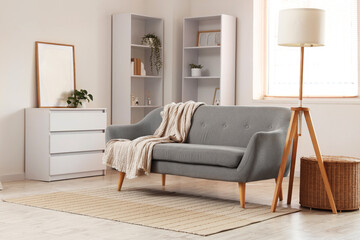 Interior design and home comfort, modern living room with grey sofa and cozy blanket in a bright minimalist apartment with wooden floor lamp © Pixel-Shot