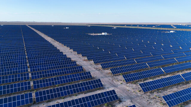 Aerial view of vast solar power station with orderly blue panels