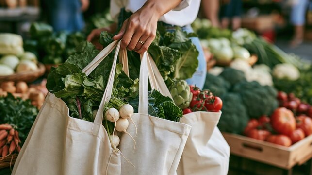 A person holding a bag filled with fresh vegetables at a market.