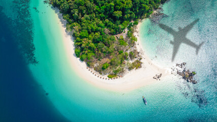 Fototapeta premium Aerial view of shadow passenger plane silhouette and sandy beach blue sea with waves at sea beach summer vacation sea travel concept 