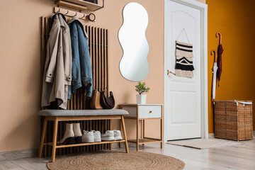 Home organization and interior design modern entryway with wooden coat rack bench and mirror in a...