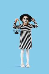 Fototapeta premium Halloween celebration and childhood imagination, little girl in skeleton makeup and striped dress holding a vintage lantern on a blue background