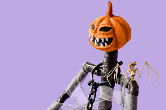 Halloween celebration and spooky holiday decor, handmade pumpkin head monster with skeleton bat on purple background for festive autumn party design