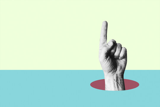 Hand pointing finger up emerging from round hole on split background