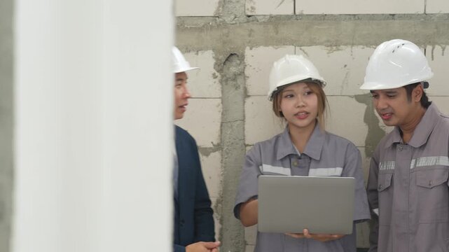 Architect, structural engineer and construction worker review project information together while discussing building progress at residential construction site.