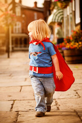 Child in superhero costume walking down sunny street © Rawpixel.com