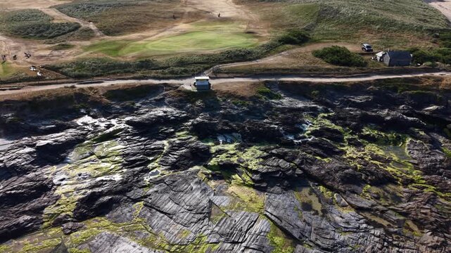 Constantine Bay, England, United Kingdom - 23 July 2026: Aerial view of the rugged rocky coastline and sandy beach at Constantine Bay.