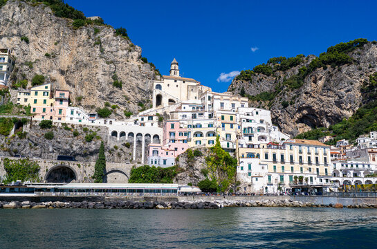 Facades of famous town of Amalfi, located on the Amalfi Coast, with its azure sea and beautiful colorful cliffside houses.