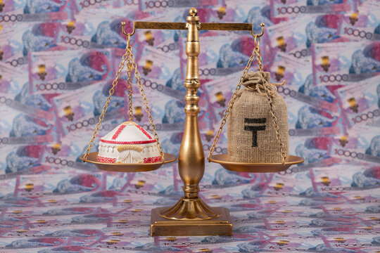 A symbolic Kazakh yurt resting on a scale against a background of 10,000 Kazakhstani tenge banknotes.