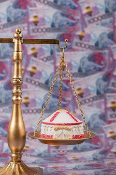 A symbolic Kazakh yurt resting on a scale against a background of 10,000 Kazakhstani tenge banknotes.