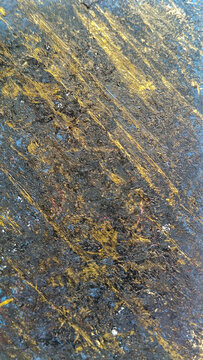 Dark vertical slate texture with parallel golden scratches and lines. Abstract metallic stone background, premium material design panel.