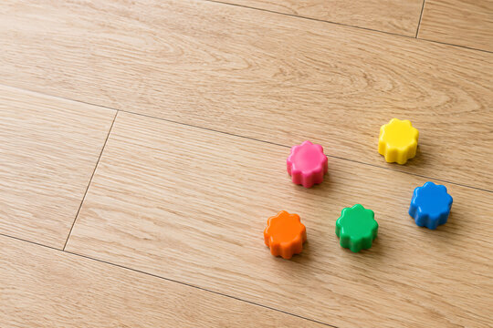 Colorful Korean gonggi game pieces on light wooden floor