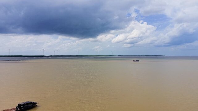 Footage shows Con Nhan Beach in Vinh Long, Vietnam. The video captures boats moving on the water under a cloudy sky. Enjoy the natural beauty of this tourist area.