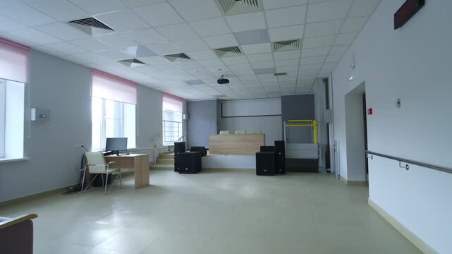 Modern lecture hall features pink window blinds ceiling with air vents wall handrails. Bright space promotes formal gathering events