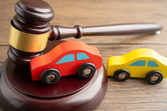 Car accident lawsuit and insurance, Judge hammer with car model.