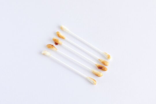 Pile of dirty cotton swabs with ear wax on white background