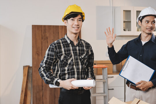 Asian architect and engineer team checking architectural house model using measuring tape on the table at office studio.