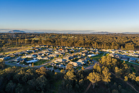 residential housing area at edge of town in afternoon light from aerial view