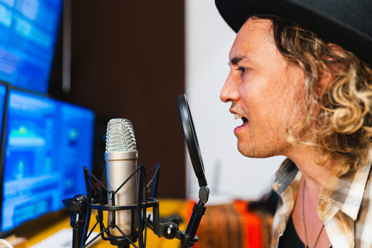 Independent music producer recording vocals in studio