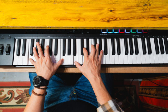 Music producer playing digital keyboard creating new sound