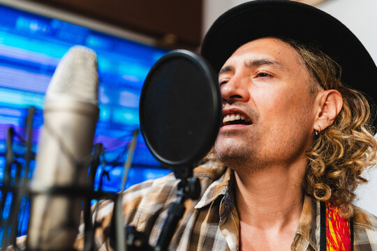 Male musician recording vocals in music studio