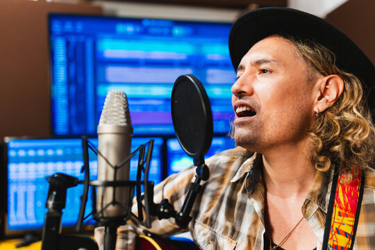 Musician singing into microphone recording new song in studio