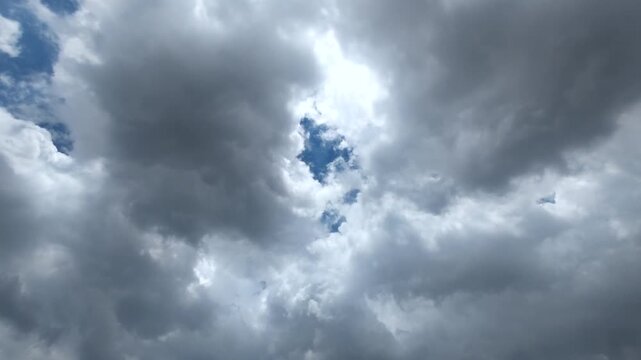 Time lapse of moving clouds mixing dark grey cloud and blue sky