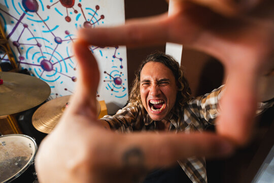 Music producer making frame with hands shouting in studio
