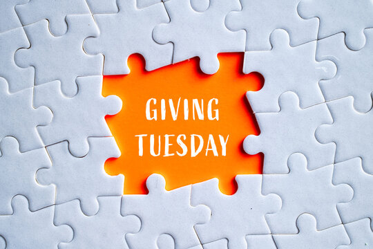 Giving Tuesday text on orange missing puzzle piece in white jigsaw background, charity and philanthropy concept