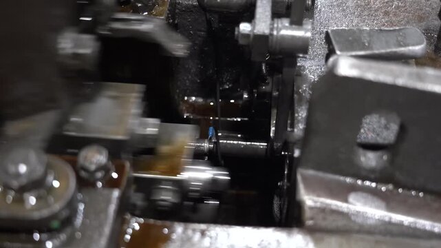 Close view of transfer fingers and cutting dies working inside an automatic screw heading machine