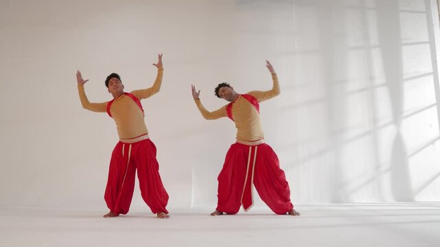 Two men performing a synchronized dance routine in an Indian studio