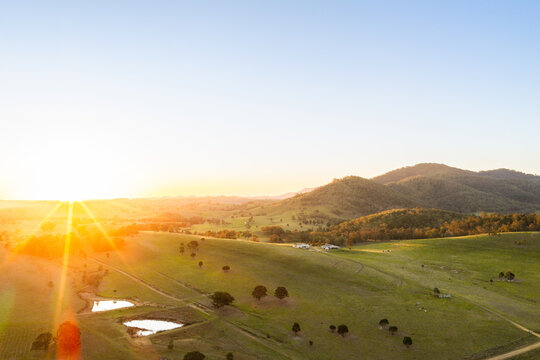 golden sunset light rays over rural farm landscape of Glendon Brook NSW Australia