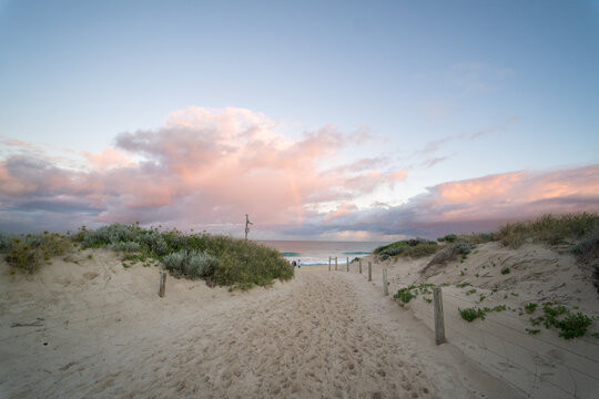 Pathway and coastal sand dunes, pastel sunset sky at Scarborough Beach, Perth, Western Australia